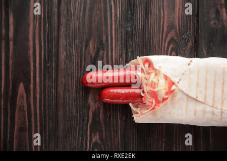 Ausschreibung Wurst in pita Brot auf hölzernen Hintergrund. Foto mit Kopie Raum Stockfoto