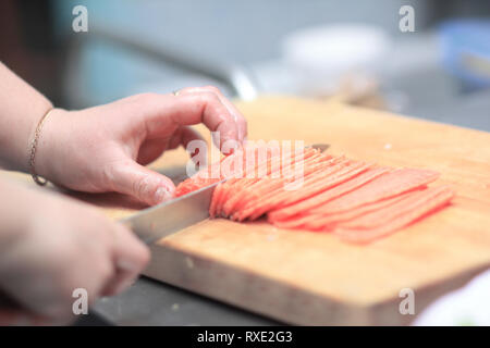 Bis zu schließen. Küchenchef schneiden Fisch für Sushi Stockfoto