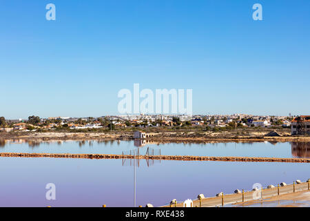 Ufer einer salzhaltigen See, wie ein Spiegel, mit Torrevieja Stadt auf dem Hintergrund Stockfoto