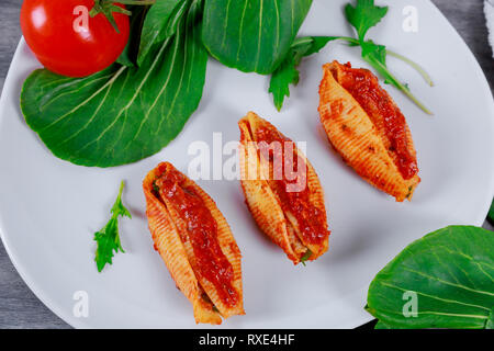 Gemüse, serviert in Jumbo pasta Muscheln mit Kräutern und Tomatensauce. Stockfoto