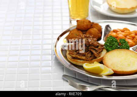 North Carolina Grill Platte; zog Schweinefleisch, Hush Puppies, baked Beans und Krautsalat Stockfoto