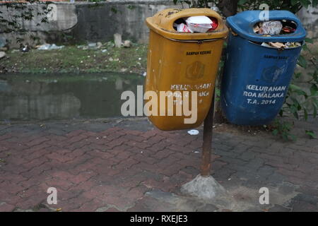 Zwei komplette Mülltonnen aus Kunststoff an einem öffentlichen Ort neben einem Fluss in Jakarta, Indonesien. Stockfoto