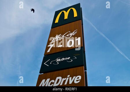 McDrive und McCafe Zeichen mit Wegbeschreibung und Öffnungszeiten Stockfoto