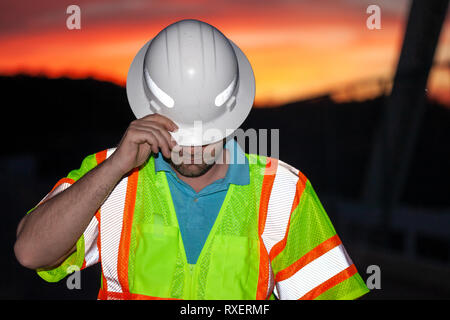 Bauarbeiter das Tragen von Schutzbekleidung mit Schutzhelm, teilweise bedeckte sein Gesicht Stockfoto