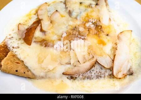 Blick von oben auf die Crepes mit Gorgonzola und Birne Schichten schließen bis auf weiße Platte in einem lokalen Restaurant in der Lombardei Stockfoto