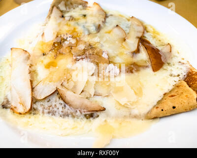 Crepes mit Gorgonzola und Birne Schichten schließen bis auf weiße Platte in einem lokalen Restaurant in der Lombardei Stockfoto