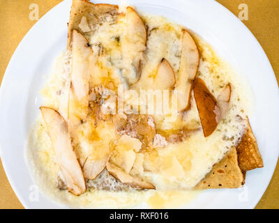 Blick von oben auf die Crepes mit Gorgonzola und Birne Slices auf weiße Platte in einem lokalen Restaurant in der Lombardei Stockfoto