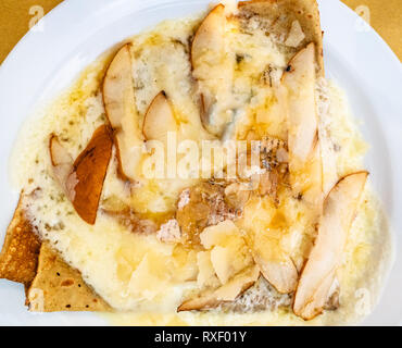 Blick von oben auf die Crepes mit Käse und Birnen Slices auf weiße Platte in einem lokalen Restaurant in der Lombardei Stockfoto