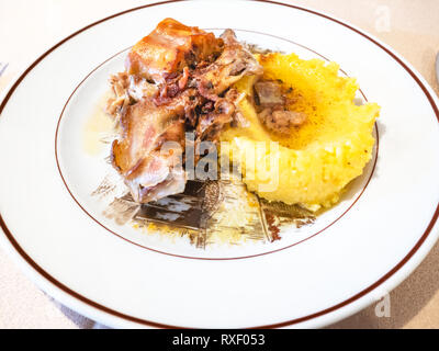 Italienische Küche - Coniglio con Polenta (Eintopf Stücke von Kaninchen mit Maisbrei) an der Platte in einem lokalen Restaurant in der Lombardei Stockfoto