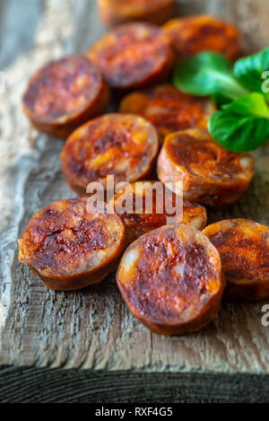 Scheiben mit spanischer Chorizo auf das Holzbrett Stockfoto