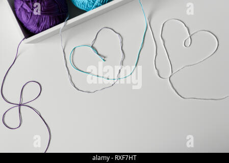Romantic design with heart symbols on a white background made from colorful cotton threads from knitting yarn. Stockfoto