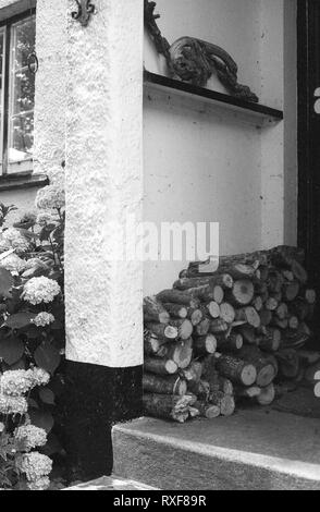 Front Porch von Oak Tree Cottage, North Bovey, Devon, UK, mit Log-Stapel Stockfoto