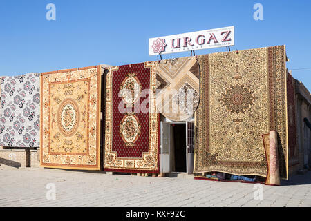 Buchara, Usbekistan - Oktober 19, 2016: Teppich Shop in Buchara. Der Name Urgaz gilamlar Übersetzt aus USBEKISCHEN wie Teppiche. Die männliche Verkäufer oder Wächter Stockfoto