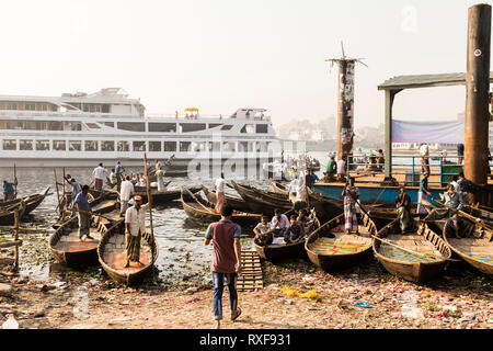 Dhaka, Bangladesh, 24. Februar 2017: Kleine Ruderboote dienen als Taxi zwischen den beiden Ufern des Flusses auf der Buriganga Fluss in Dhaka, Bangladesch, im Hinterg Stockfoto