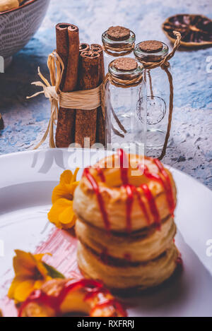 Vertikale Foto mit wenigen Zimtstangen durch natürliche Kabel verbunden. Pikant Sticks sind neben drei kleinen Glasflaschen von Kork Siegel verschlossen. Brille Stockfoto
