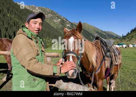 Altyn-Arashan, Kirgisistan, 14. August 2018: Eine junge Kirgisische liebevoll Anschläge ein Pferd in das Tal von Altyn-Arashan in Kirgisistan Stockfoto