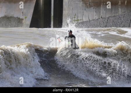 Hastings, East Sussex, UK. 10 Mär, 2019. UK Wetter: Gale force Winde Toben bringen Meere zu Hastings in East Sussex. Surfer und bodyboardern mutig die raue See springen vom Hafen arm. © Paul Lawrenson 2019, Foto: Paul Lawrenson/Alamy leben Nachrichten Stockfoto