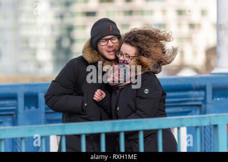 Starke Winde haben die Hauptstadt getroffen, als Leute, die Tower Bridge, London, UK Kreuz während der Vitalität große Halbmarathon Stockfoto