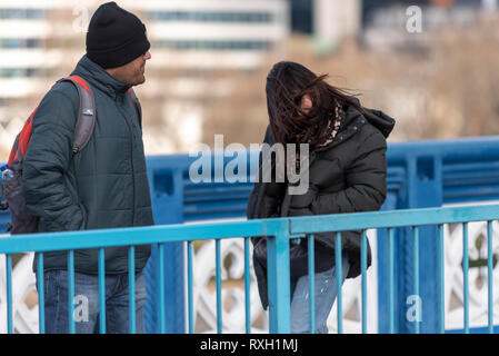 Starke Winde haben die Hauptstadt getroffen, als Leute, die Tower Bridge, London, UK Kreuz während der Vitalität große Halbmarathon Stockfoto