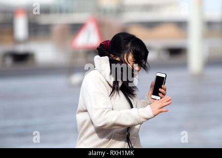 Blackpool, Großbritannien. 10. März, 2019. Strong gale force Winde an der Küste. Shopper sind windswept als der starke Stürmische Winde fegen durch die Innenstadt. Wetter Warnungen haben sich über den Nordwesten von England bei starken Windböen und Regen über das Wochenende ausgestellt wurde. . Credit: MediaWorldImages/Alamy leben Nachrichten Stockfoto