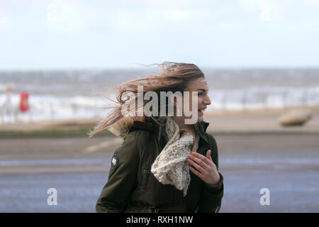 Blackpool, Großbritannien. 10. März, 2019. Strong gale force Winde an der Küste. Shopper sind windswept als der starke Stürmische Winde fegen durch die Innenstadt. Wetter Warnungen haben sich über den Nordwesten von England bei starken Windböen und Regen über das Wochenende ausgestellt wurde. Credit: MediaWorldImages/Alamy leben Nachrichten Stockfoto