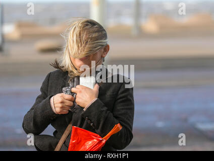 Blackpool, Großbritannien. 10. März, 2019. Strong gale force Winde an der Küste. Shopper sind windswept als der starke Stürmische Winde fegen durch die Innenstadt. Wetter Warnungen haben sich über den Nordwesten von England bei starken Windböen und Regen über das Wochenende ausgestellt wurde. Credit: MediaWorldImages/Alamy leben Nachrichten Stockfoto