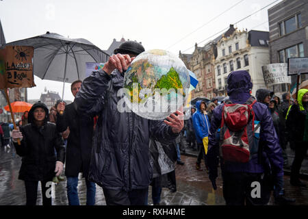 Einige Teilnehmer im März gegen den Klimawandel tragen Globen in allen Größen. Die von der bürgerlichen Vereinigungen und NRO beschworen wurde, Tausende von Menschen demonstrierten heute in Amsterdam zu verlangen, dass die Regierungen entscheidend in die angesichts der immer drohenden Gefahr des Klimawandels handeln. Stockfoto