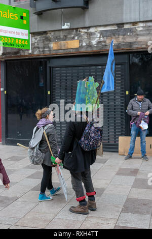 Cardiff, Wales, UK. 10. Mär 2019. Aussterben Rebellion März Oberflächen jenseits von Barclays. Das Aussterben Rebellion ist eine internationale soziale Bewegung, die darauf abzielt, einen radikalen Wandel durch gewaltfreien Widerstand zu fahren. März dieses Jahres fand in Cardiff statt Schließung die Castle Street. Der Protest war außerhalb Barclays Barclays Investitionen in fossile Brennstoffe zu markieren. © JaiAshton Credit: Jai Ashton/Alamy leben Nachrichten Stockfoto