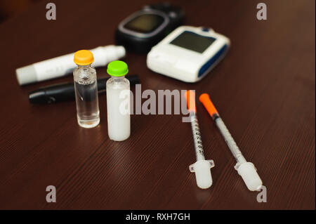 Medizin, Diabetes und Health Care Concept - Nahaufnahme der Blutzuckertest Streifen, glucometer, Diabetes Insulin pen und anderen Tools auf Tisch. Stockfoto