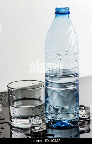Verschwitzte gekühltes Mineralwasser, Eiswürfel und Glas Stockfoto