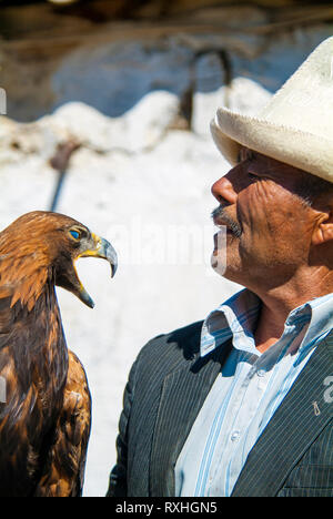 Eagle Hunter Saginbai und einer seiner Adler in Bokonbaevo Dorf an den Ufern des Sees Issyk Kul in Kirgisistan. Jagd mit Adlern ist ein traditionelles Stockfoto