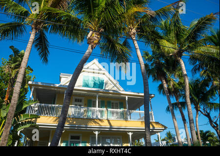 Malerischer Blick auf typischen hölzernen Conch Haus mit Terrasse mit Blick auf Palmen gesäumten Straße in der Altstadt von Key West, Florida, USA Stockfoto