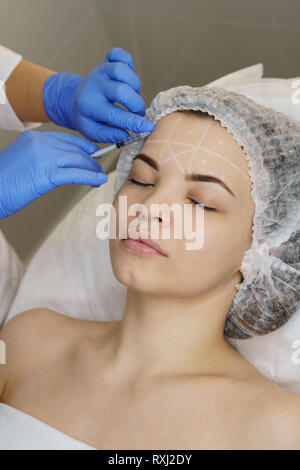 Ästhetische Kosmetologie. Facelift in Spa Salon. Kosmetikerin macht Injektion Mädchen. Glättung von Falten nachahmen. Stockfoto