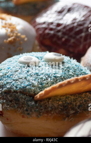 Leckere frisch gebackene Berliner mit verschiedenen Toppings closeup Stockfoto