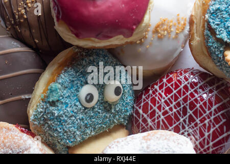 Leckere frisch gebackene Berliner mit verschiedenen Toppings closeup Stockfoto