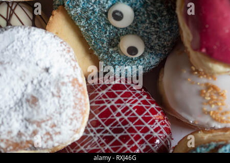 Leckere frisch gebackene Berliner mit verschiedenen Toppings closeup Stockfoto