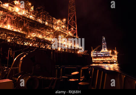 FPSO-tanker Schiff in der Nähe der Bohrinsel Bohrinsel in der Nacht. Offshore Öl- und Gasindustrie Stockfoto