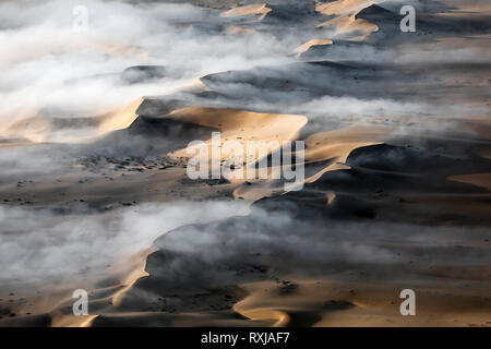 Nebel hängt über den Sanddünen des südlichen Namibia niedrig. Stockfoto