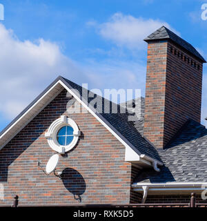 Asphalt Kies. Dekorative bitumen Schindeln auf dem Dach eines Brick House Stockfoto