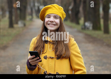 Happy Jugendmädchen hört Musik auf dem Smartphone Stockfoto