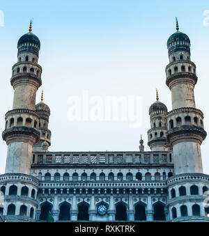 Eine schräge Ansicht der oberen Fassade und die Uhr der Charminar, "vier Minarette", Hyderabad, Telangana, Indien. Tauben sitzt in der Attika des Daches. Stockfoto