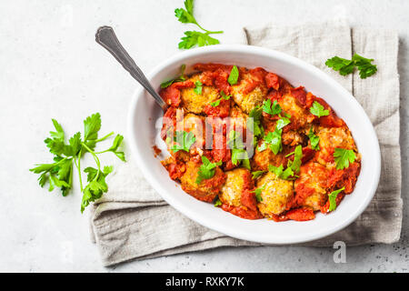 Gebackene vegan bean Hackfleischbällchen in Tomatensauce mit Petersilie in weißen Teller. Auf Basis pflanzlicher Nahrung Konzept. Stockfoto