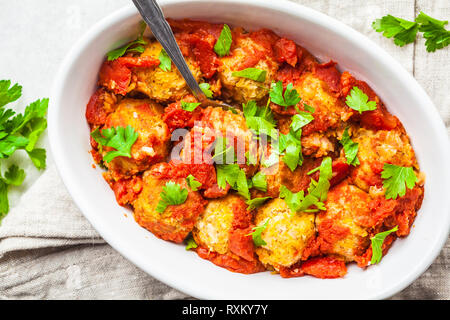 Gebackene vegan bean Hackfleischbällchen in Tomatensauce mit Petersilie in weißen Teller. Auf Basis pflanzlicher Nahrung Konzept. Stockfoto