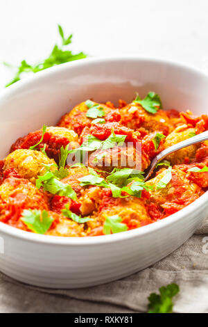 Gebackene vegan bean Hackfleischbällchen in Tomatensauce mit Petersilie in weißen Teller. Auf Basis pflanzlicher Nahrung Konzept. Stockfoto