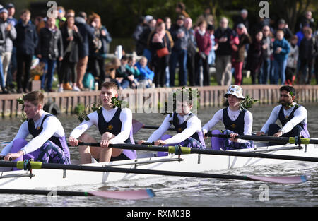 Eine Mannschaft aus magdelene College Reihe Haus mit viel Grün in Ihrem Haar eine erfolgreiche Bump während der letzte Tag der Universität Cambridge verliehen Unebenheiten auf dem Fluss Cam in Cambridge zu bedeuten. Stockfoto