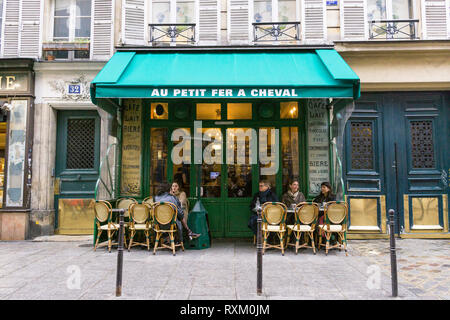 Gäste genießen Kaffee am Nachmittag im Cafe Au Petit Fer a Cheval im Marais-Viertel von Paris, Frankreich. Stockfoto