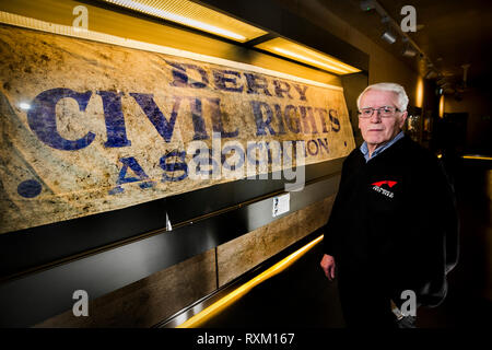 John Kelly, deren 17 Jahre alten Bruder, Michael, während der blutige Sonntag getötet wurde, steht neben der Derry Civil Rights Association Banner im Museum von Free Derry, dass an dem Tag, als blutiger Sonntag bekannt ist, durchgeführt wurde. Die Staatsanwaltschaft wird erwartet, zu verkünden, ob es Ermittlungen gegen Soldaten über den Tod von 13 Menschen in Londonderry am 30. Januar 1972 fortzusetzen. Stockfoto