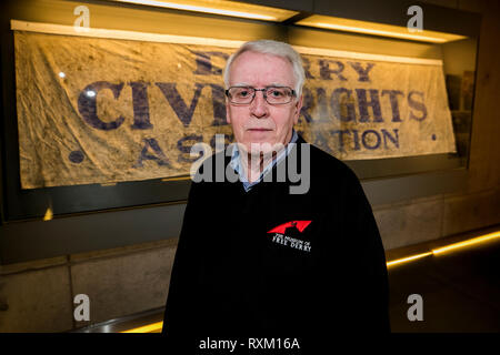 John Kelly, deren 17 Jahre alten Bruder, Michael, während der blutige Sonntag getötet wurde, steht neben der Derry Civil Rights Association Banner im Museum von Free Derry, dass an dem Tag, als blutiger Sonntag bekannt ist, durchgeführt wurde. Die Staatsanwaltschaft wird erwartet, zu verkünden, ob es Ermittlungen gegen Soldaten über den Tod von 13 Menschen in Londonderry am 30. Januar 1972 fortzusetzen. Stockfoto