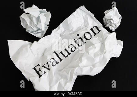 Zerknittertes Papier Blatt mit Word Bewertung isoliert auf Schwarz Stockfoto