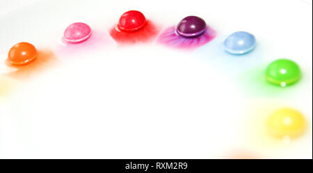 Die Bonbons lösen sich im Wasser und bilden eine bunte Show. Stockfoto